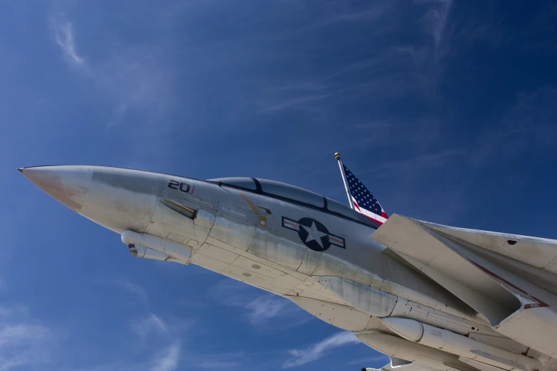 the bottom view of an american fighter jet, under a clear blue sky