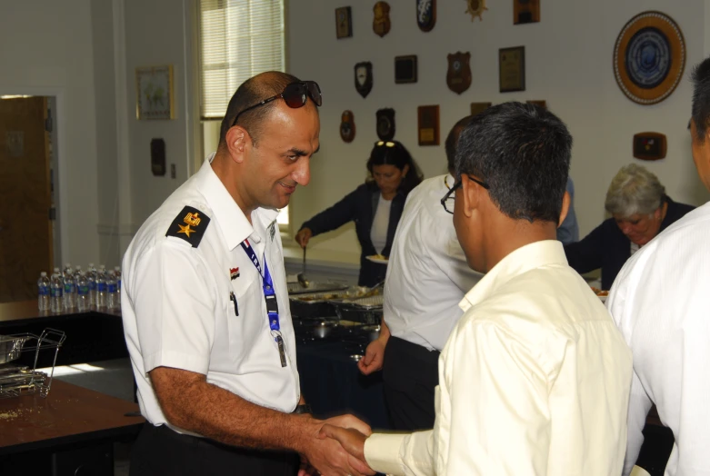 three uniformed people are greeting each other and shaking hands