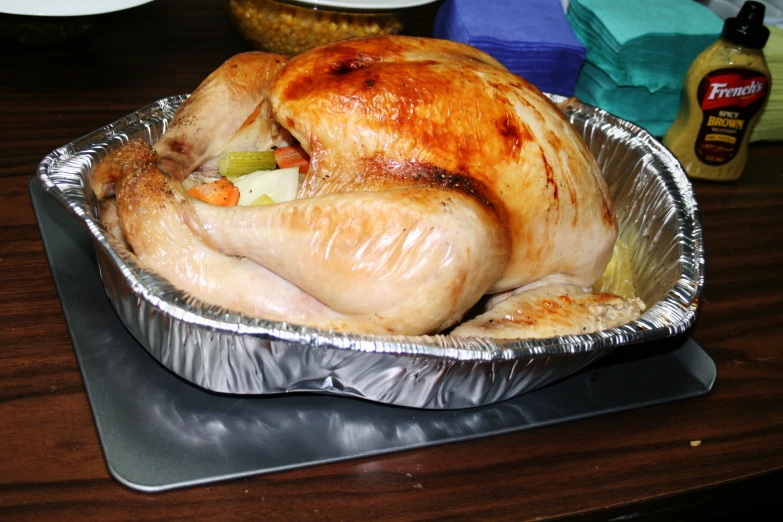 a turkey is shown sitting in foil on a wooden table
