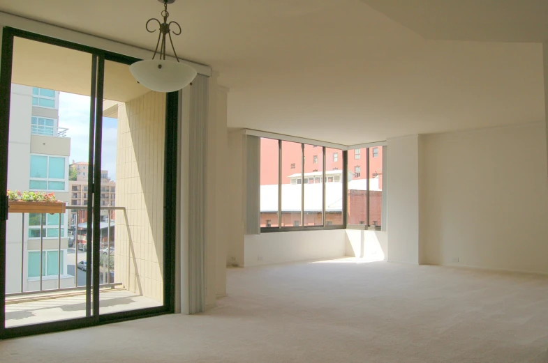 empty living room with big windows and sliding glass door