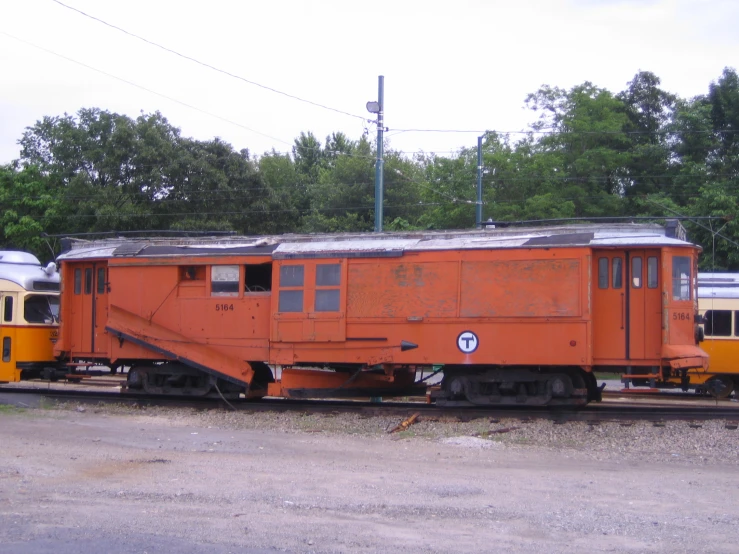 a group of orange train cars parked in a train yard