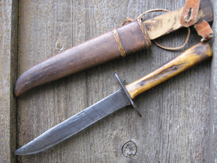 two vintage knives sitting on top of a wooden surface