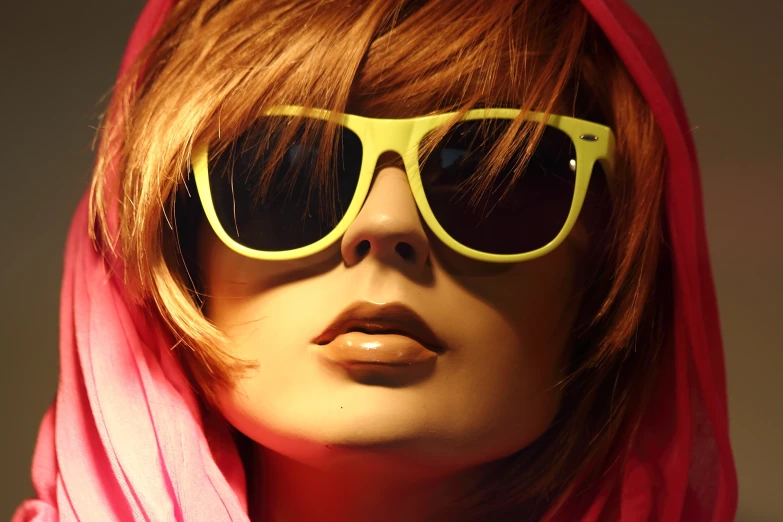 an attractive woman wearing yellow sunglasses with a red scarf over her head