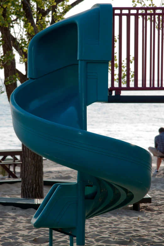 a play area with a slides and a bench