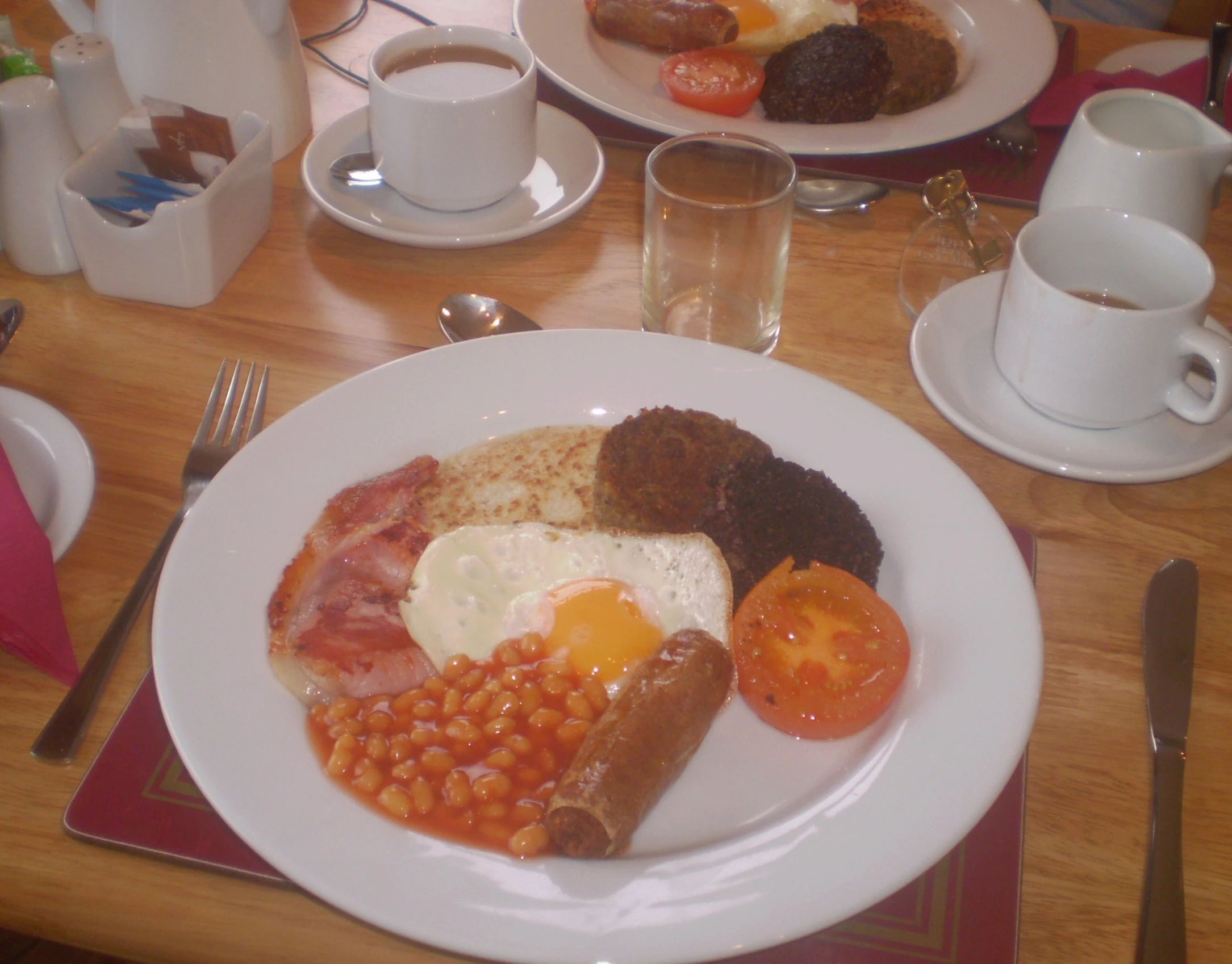 an english breakfast with beans, bacon, tomatoes, and eggs