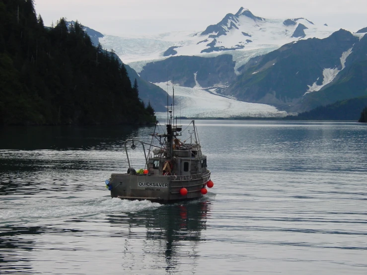 boat on open water with snowy mountains in the background