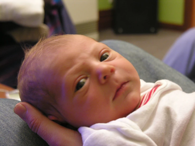 a baby sitting on a chair and looking at the camera