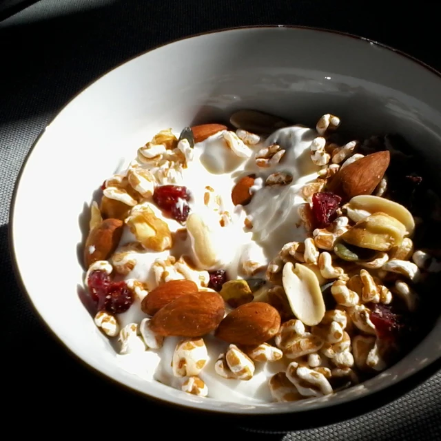 a bowl filled with fruit, nuts and yogurt