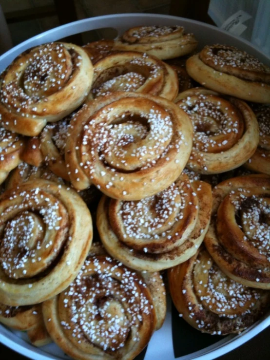 a plate of cinnamon rolls covered with powdered sugar