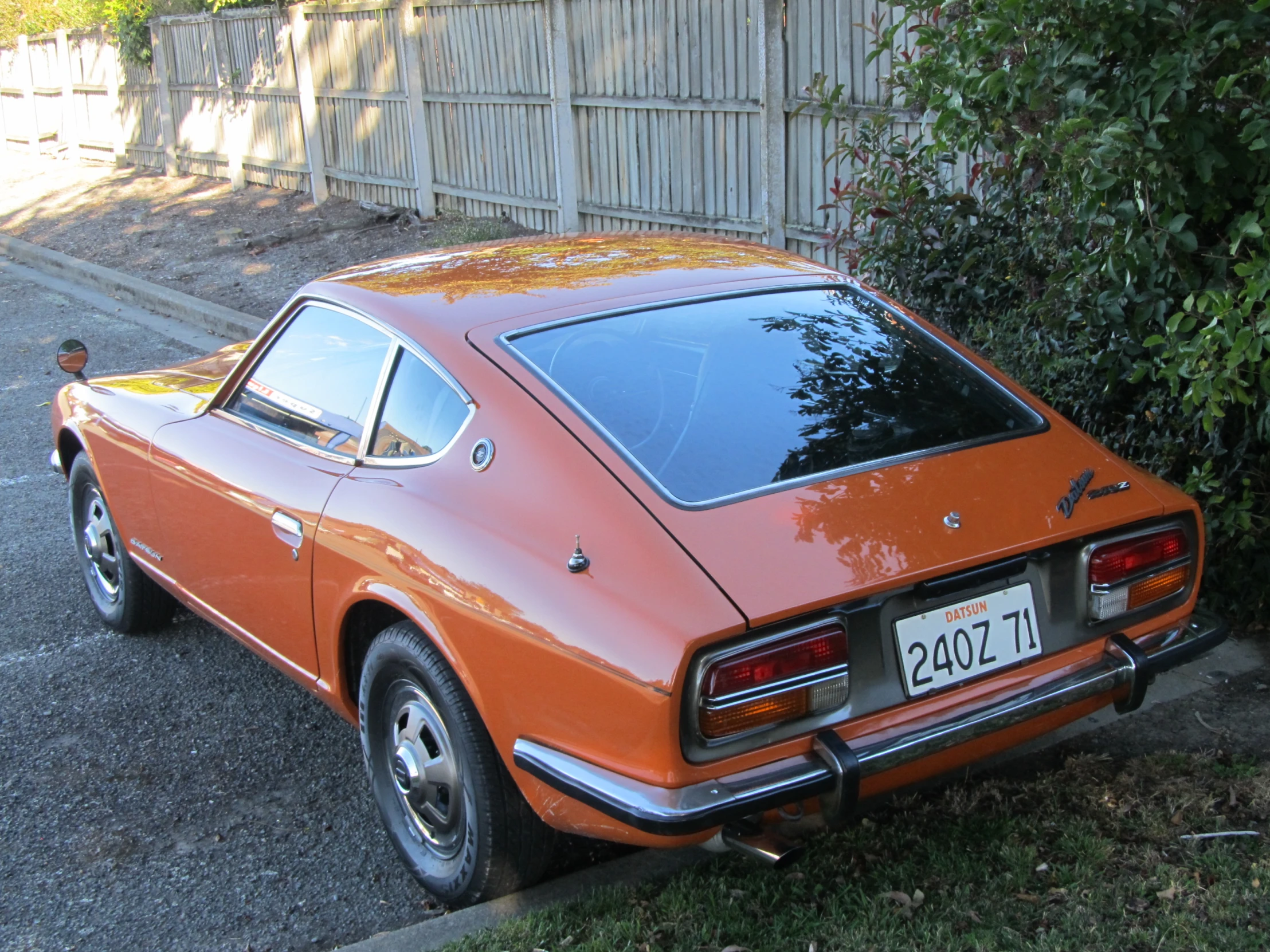 an old orange car parked next to a wall