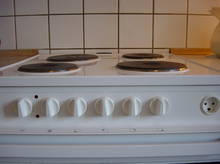 a white stove with six burners sits in the kitchen