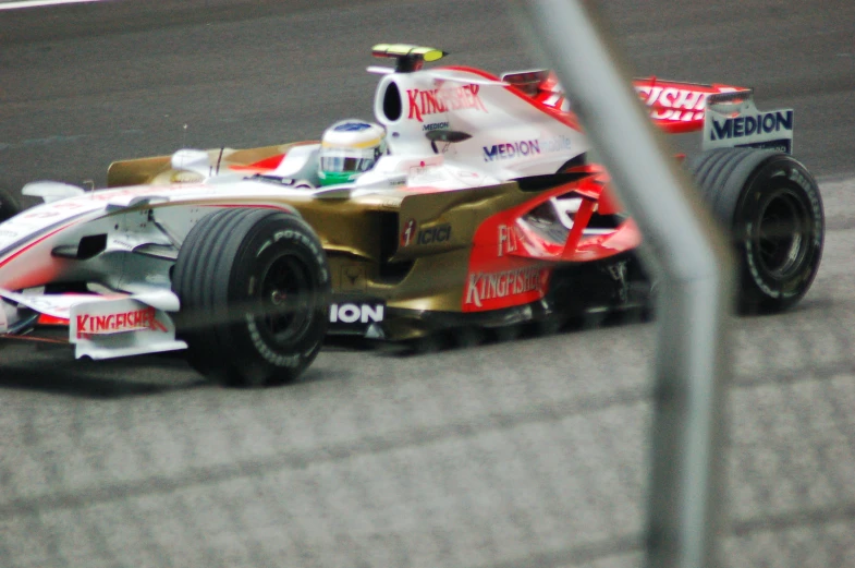 a red and white car drives around the track