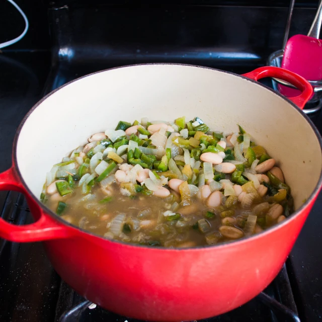 beans and onions cooking in a red pot