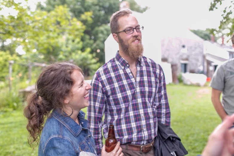 two people in jeans and red and blue plaid shirts talking