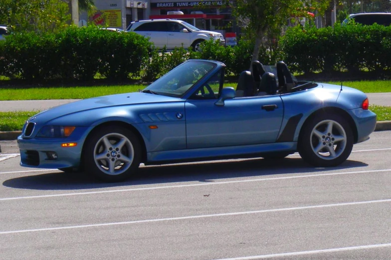 a car parked in a parking lot with two wheels and a top down