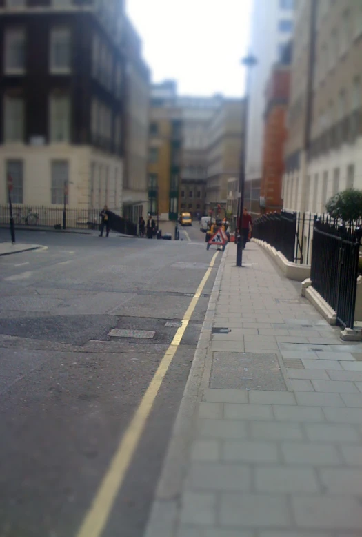 the narrow street is lined with people and cars