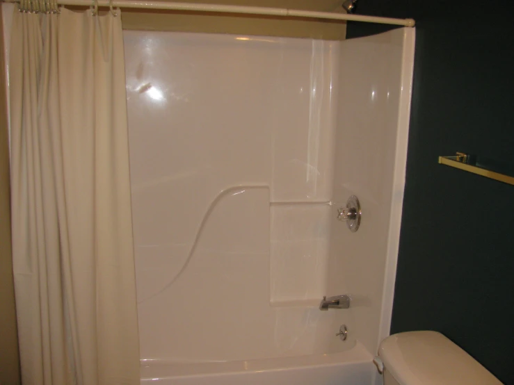 a white toilet sitting next to a bath tub under a shower curtain