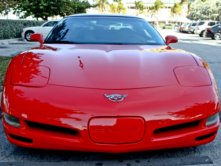 the front end of a red sports car parked on a street
