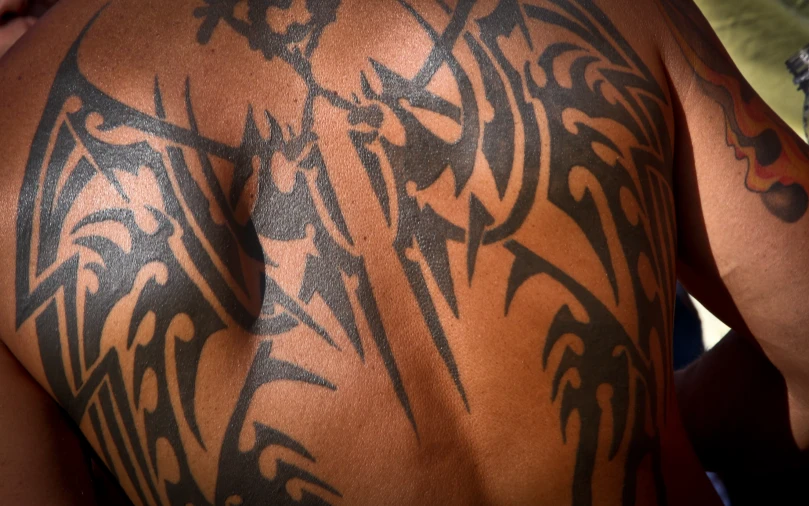 an intricate tattoo design on the back of a man