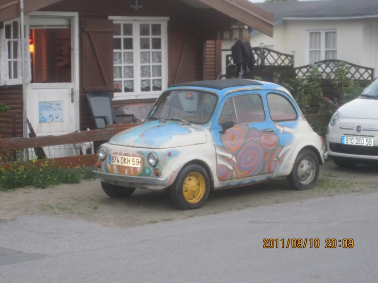 a blue and white car is parked in front of a building