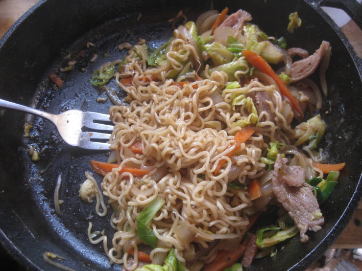 noodles, meat, and veggies being cooked in a set