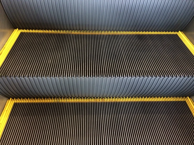 the top half of an escalator that has many stripes and yellow