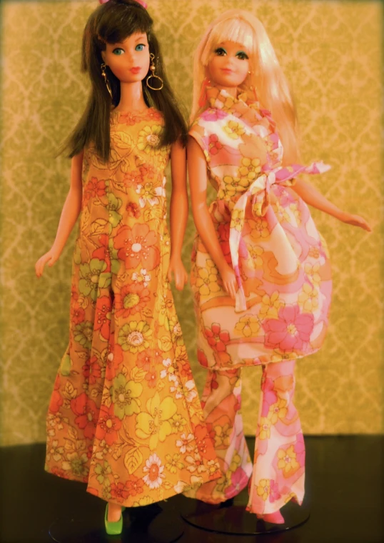 two dolls standing beside each other wearing dress