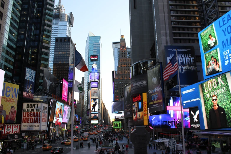 a busy city street with tall buildings and advertits