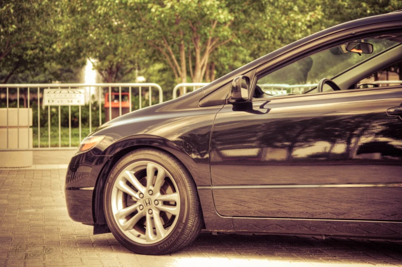 a small black car parked outside on the side of the road