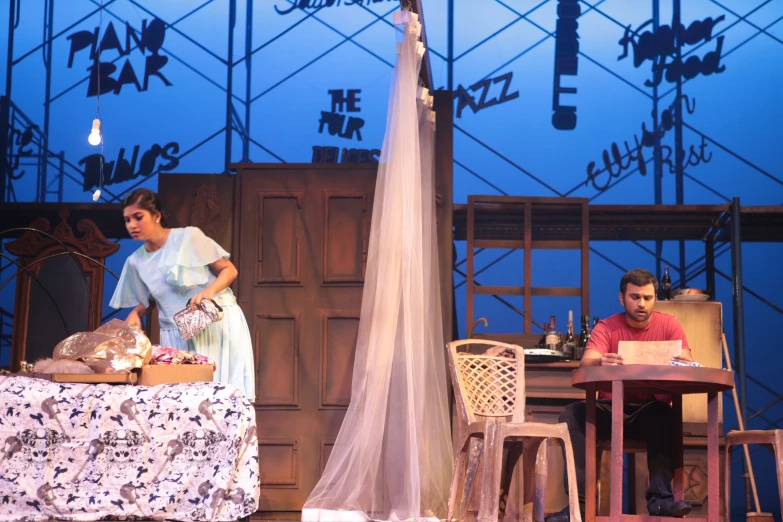 actors at table, chairs and stage lighting