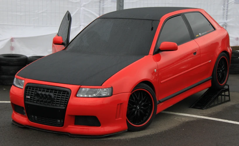 a car parked in a parking lot with it's hood covering