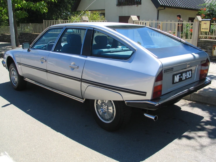 a silver car parked on the street next to another car