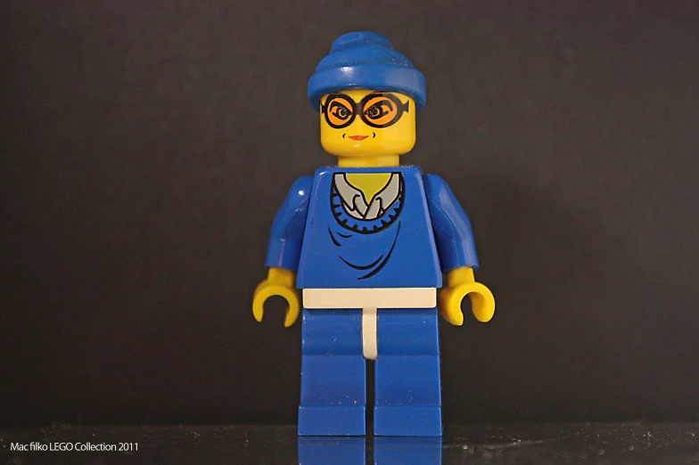 a blue lego minifig with dark background and yellow eyes