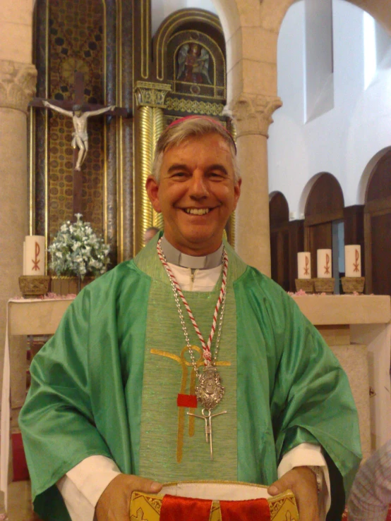 a priest wearing a green stole standing in front of a alter