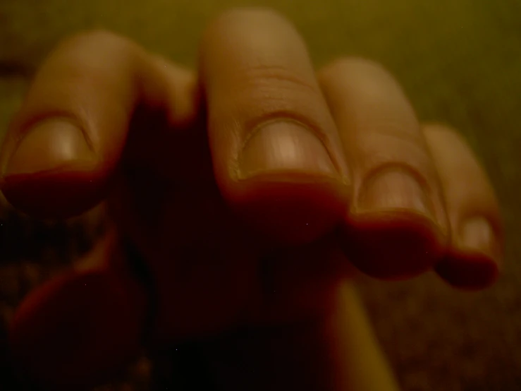 a person has their fingers with brown nail polish on