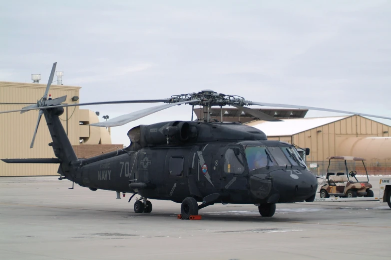 a military helicopter parked in front of a building