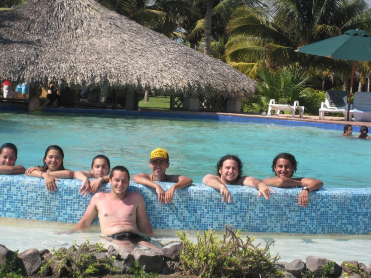 four girls and one guy taking a break at the swimming pool