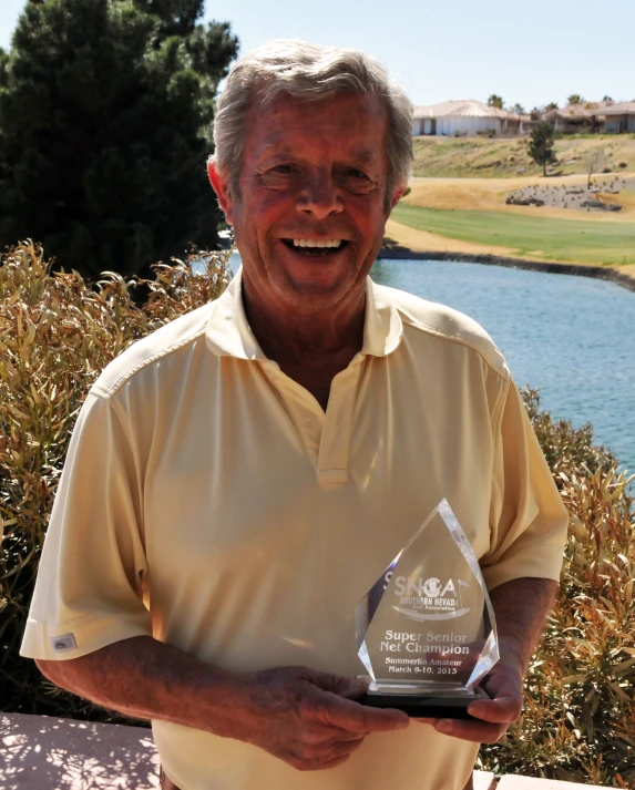 man posing with an award for his best golf score