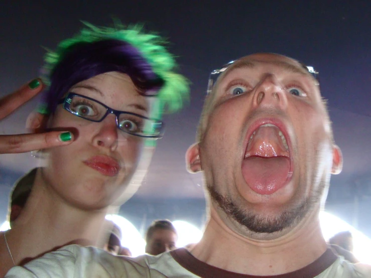 a woman has green hair and her man with the camera at his side