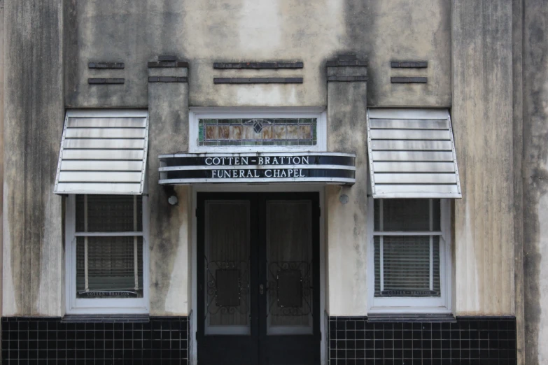 the front door of an old theater, with awnings above a door