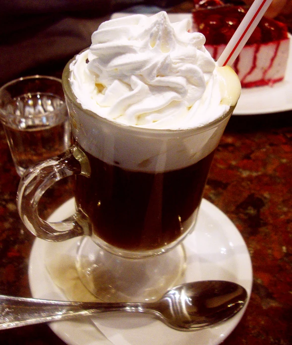 a cup filled with coffee sitting on top of a white plate