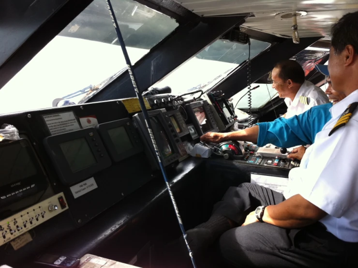 an inside view of a plane and three men operating control panels