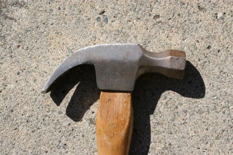 an hammer is seen from above on a dirty cement background