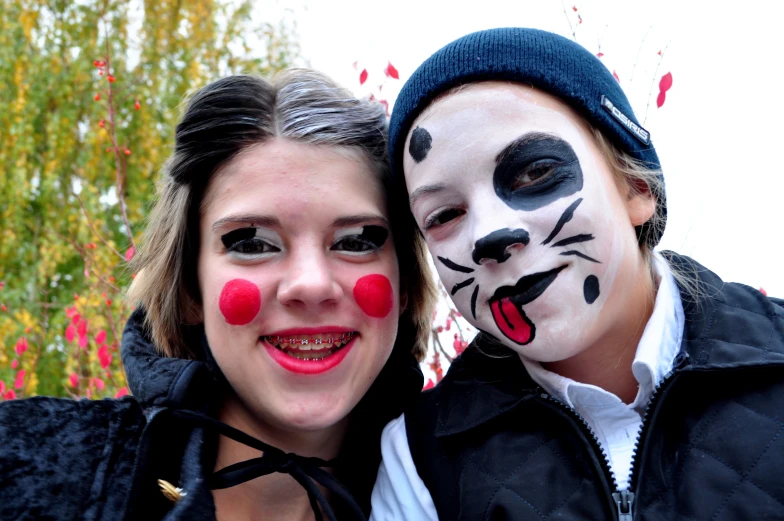 two people are wearing fake noses and painted animals