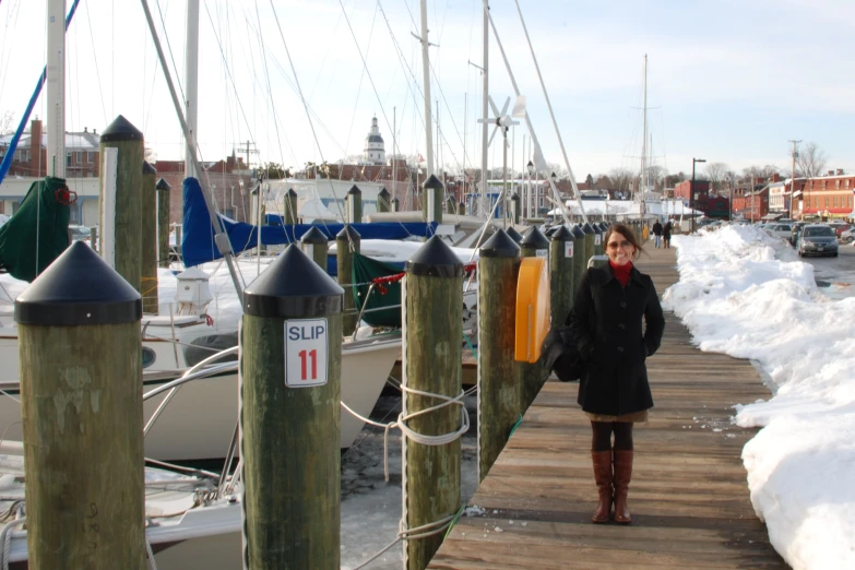 a person is standing on the side walk by boats