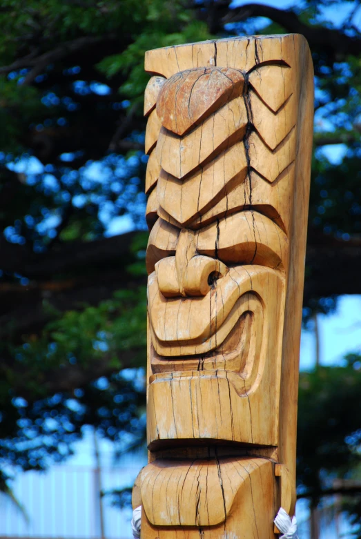 a wooden carving on display outside near a building