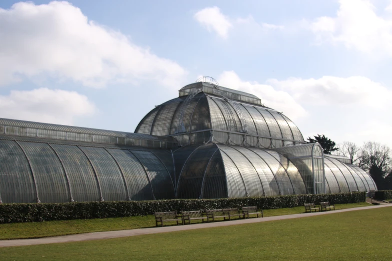 the large glass building is sitting on top of grass