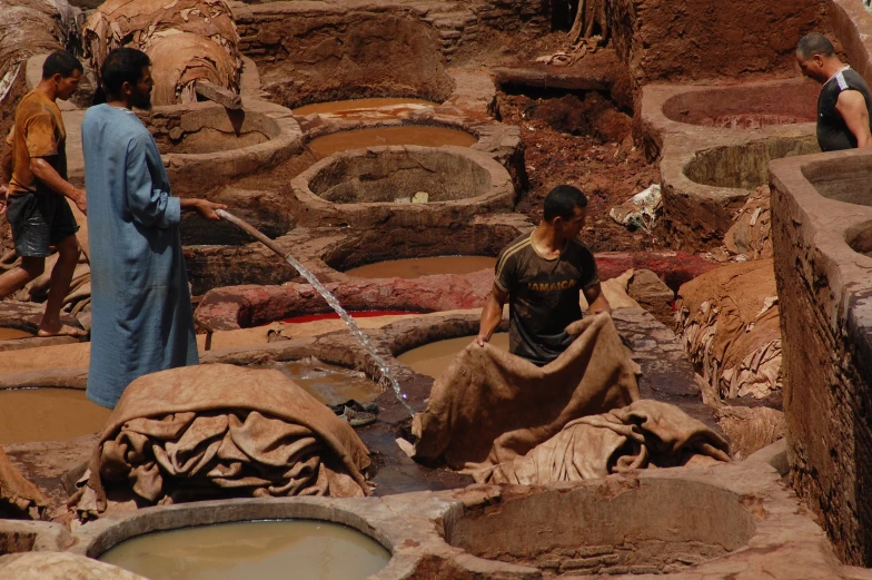 an indian woman and two s stand in a large pot pit