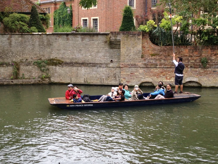 group of people on a boat in water near buildings