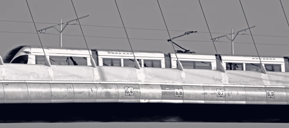 black and white po of commuter train under power lines